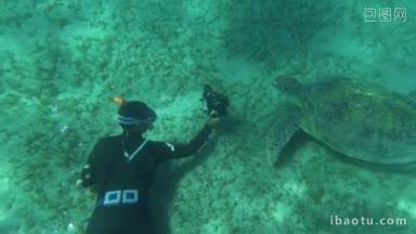 慢动作潜水者在通气管与相机拍照或拍摄视频的大海龟